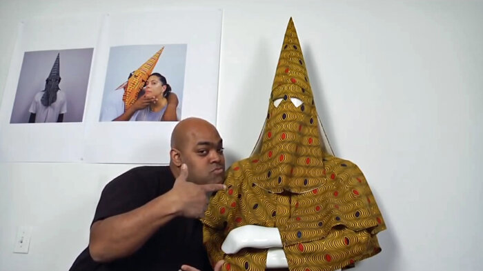 Artist Michael Paul Britto poses with his creation African Klan Suit #2 (Hypnotic), 2010.