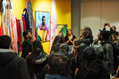 Yvena Despagne (on the left), curator of BYENVENI, takes students on a preview tour of the exhibition at the Caribbean Cultural Center African Diaspora Institute. In the background, you can see Steven Baboun’s installation and photography artwork, part of the exhibition.