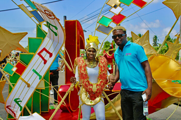 Costume designer Nelsion Nurse beside a young reveler showcasing his creation at the 2024 Children's Mashramani Costume Parade on the streets of Georgetown on Feb. 17.
