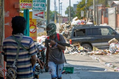 Armed members of the G9 and Family gang stand guard at their roadblock in the Delmas 6 neighborhood of Port-au-Prince, Haiti, Monday, March 11, 2024.