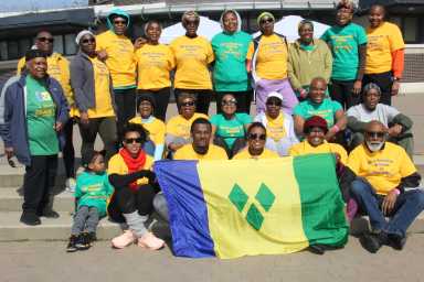 Participants display the Vincentian flag before walking.