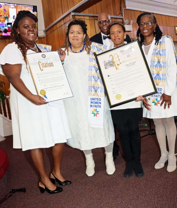 Displaying citation and proclamation from Mayor Eric Adams and State Assemblyman Brian Cunningham: From left, Shanae Als; Benita Lynn Malloy; Syndney Renwick, Cunningham’s chief-of-staff; and Marlene Ferguson. Pastor Roger Jackson is at back.