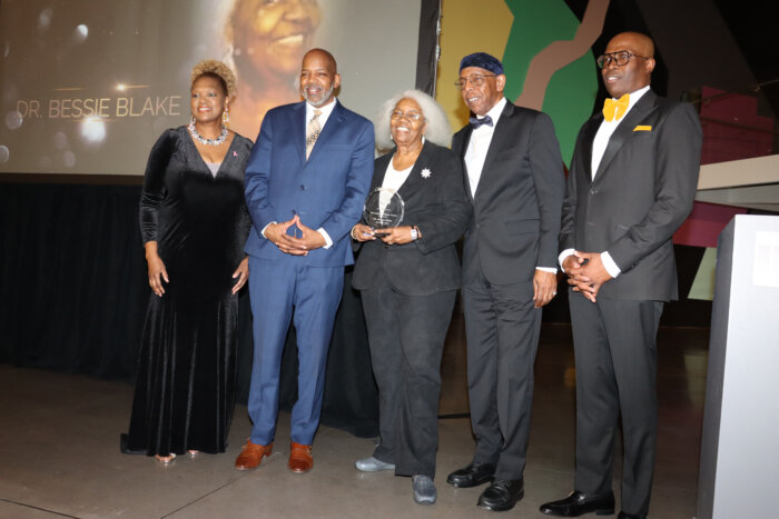 Dr. Bessie Blake, center with award, flanked by her sons and host Rose Guerrier, left, and co-host Jacques M. Leandre, right.