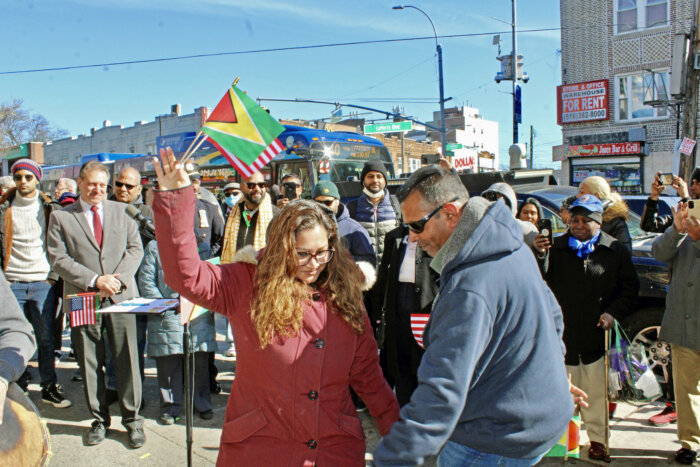 Scores of residents danced and waved Guyana's Golden Arrowhead and American flags of freedom as others looked on, during the historic unveiling ceremony of the “Welcome to Little Guyana” plaque in the mezzanine of the Lefferts Boulevard A-train station, at the intersection of Lefferts Blvd. and Liberty Avenue.
