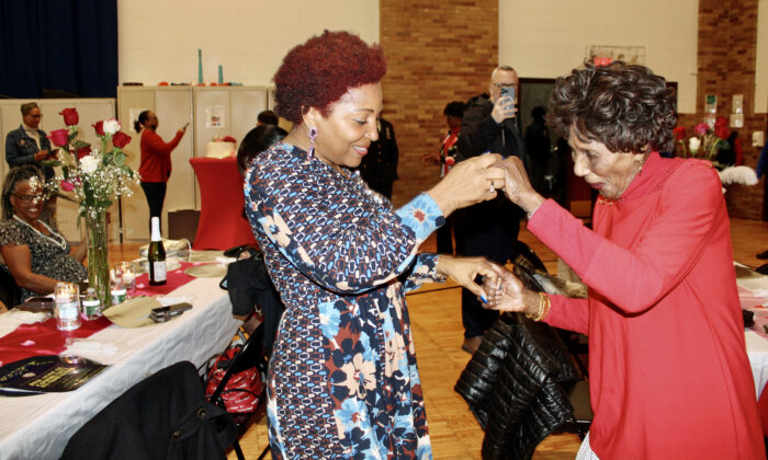 Councilmember Mercedes Narcisse engages an older adult for a dance-off at the 2nd Annual Older Adult dinner in the Holy Family auditorium on March 9.