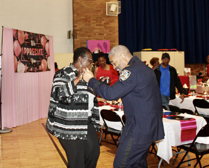 Senator Roxanne Persaud and Commanding Officer Captain Dian Hinds enjoy the music provided by DJ Chinee Golden Touch at the 2nd Annual Valentine's Dinner at in the auditorium of Holy Family Church in Canarsie, Brooklyn.