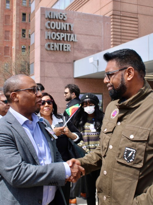 Kings County Hospital Center CEO Sheldon McLeod, extends a hand to President of Guyana Irfaan Ali, as Community Board 17 District Manager Sherif Barker, center looks on, after a tour of KIngs County Hospital Center on April 19.