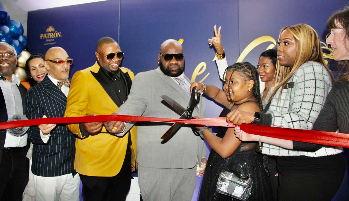 The ribbon cutting ceremony to open up-scale restaurant Le Chai on April 16, attracted a large crowd. From left, Brooklyn Chamber of Commerce Ambassador Kenneth Marble, a supporter, (partly hidden), co-owners, Sting International, David L. Thomas, Carlson Small, daughter Madelynn Thomas cutting the ribbon, Camille Hastick, Councilmember Farah Louis, and a Brooklyn Chamber of Commerce Ambassador.