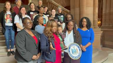 Asseemblywoman Rodneyse Bichotte Hermelyn with her son, Daniel, Sen. Lea Webb, third from left, Sen. Roxaane Persaud, left, and other elected officials and advocates.