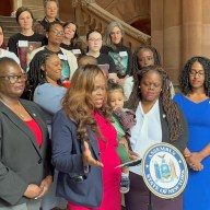 Asseemblywoman Rodneyse Bichotte Hermelyn with her son, Daniel, Sen. Lea Webb, third from left, Sen. Roxaane Persaud, left, and other elected officials and advocates.