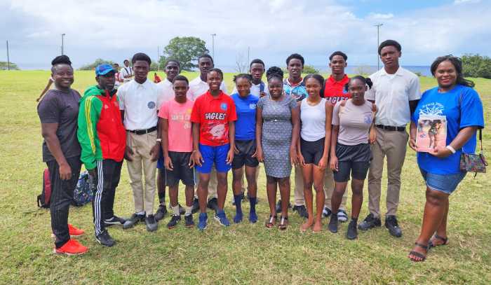 Kylla Herbert, (right) president South Jersey Caribbean Cultural and Development organization with the Charles E. Mills Secondary School's coaching staff and the athletes in February 2023
