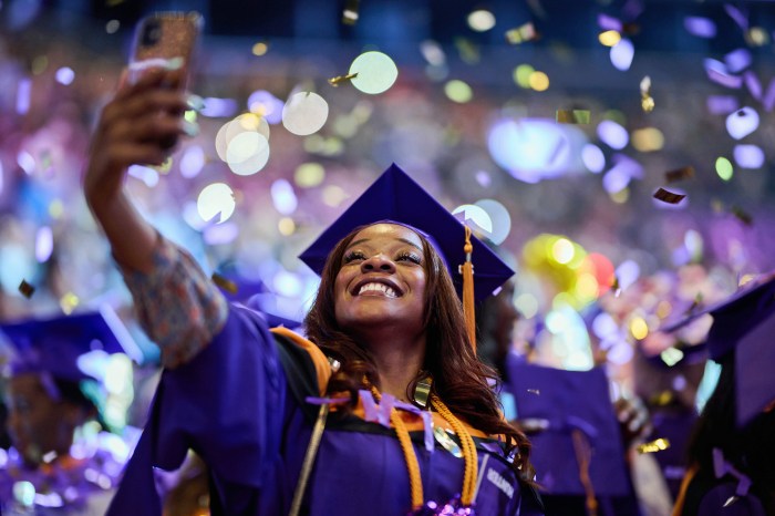 Graduate taking selfie while confetti falls at the 2023 Hunter College commencement held at the Barclays Center, Brooklyn.