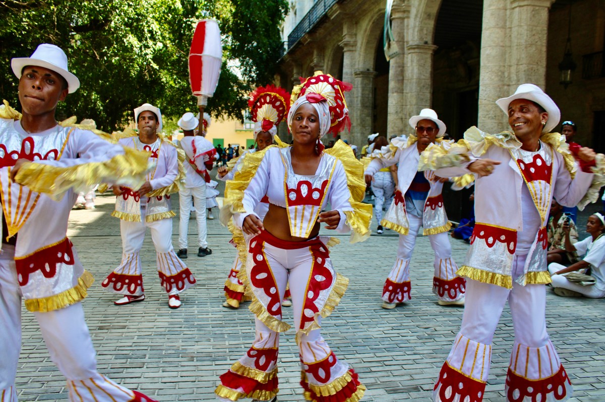 A colourful, marching band danced through the streets of Havana, as tourists looked on.