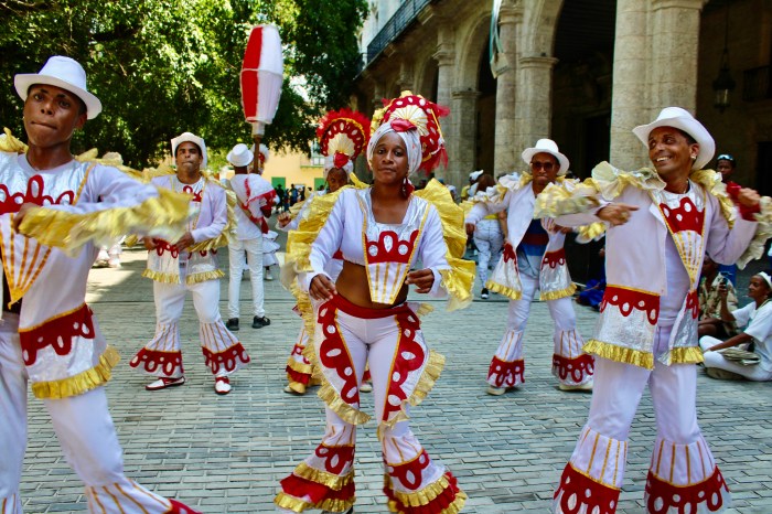 A colourful, marching band danced through the streets of Havana, as tourists looked on.