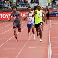 Kevin Davin (in neon green) pulls away from the pack to win the 4x400m on Saturday for the St. Vincent Grammar School.