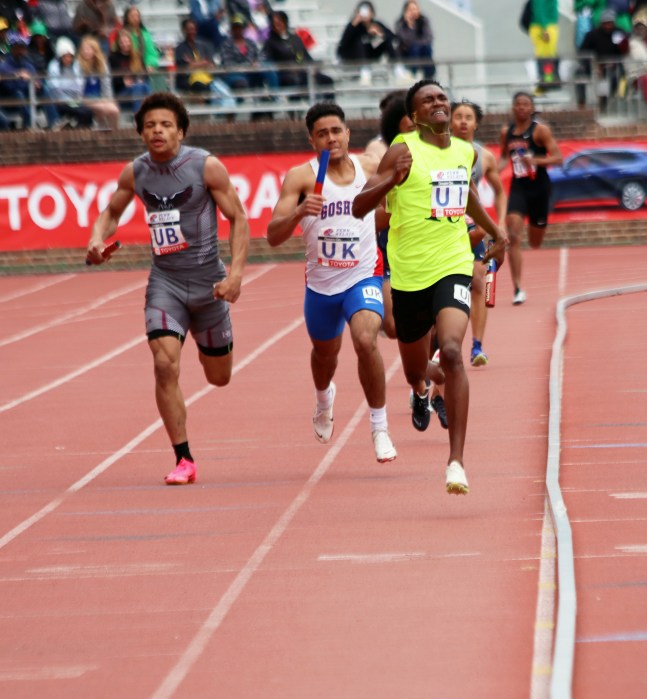Kevin Davin (in neon green) pulls away from the pack to win the 4x400m on Saturday for the St. Vincent Grammar School.