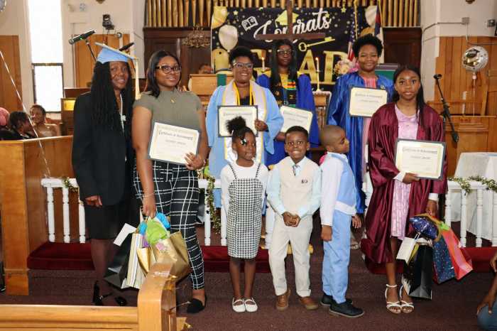 Education and Higher Education Committee Chair Dianne Brown, far left, with cap and gown, with graduates displaying certificates and gifts.