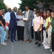 Pastor Louis H. Straker, Jr., in blue suit, fourth from left, presents check to Verna Arthur, to his immediate left, and Consul General Rondy "Luta" McIntosh, flanked by parishioners and members of the SVG Relief Committee USA, Inc.