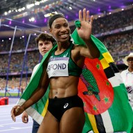 Thea LaFond of Dominica celebrates with her national flag after winning gold.