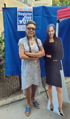 Jamaican Sonia Chin stands beside a cardboard pop up of VP Kamala Harris.
