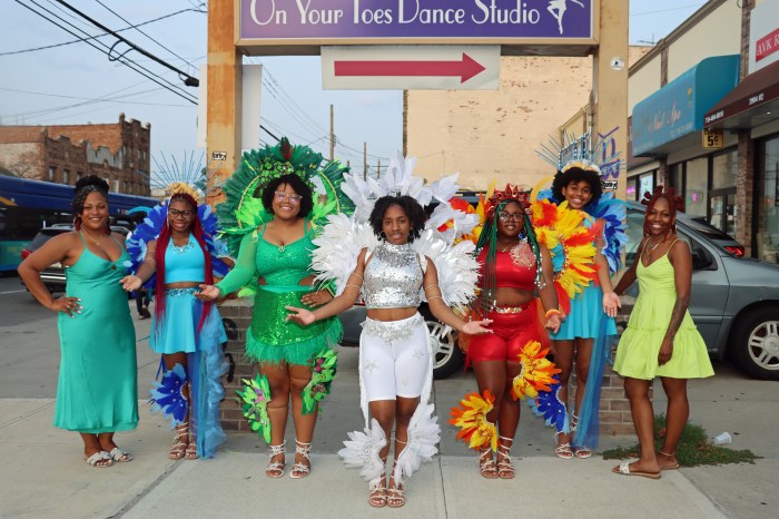 Band leader Althea Holmes, left, and designer Jessica Justice, right, with masqueraders from On Your Toes.