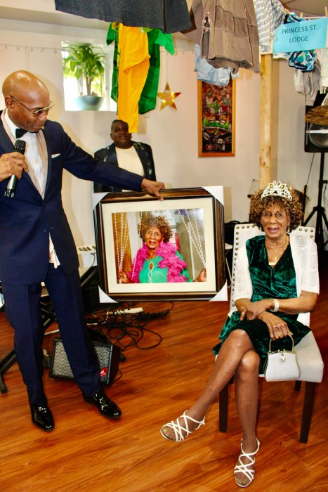 Norma Clarke, 94, smiles as she is presented with her beautiful portrait, done by NATGEO photographer Colin "SoulBoy" Williams, left, during the 14th Annual Yesterday's Children 14th Annual Community Salute on Oct. 13, in Queens.