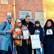 NYC Public Advocate Jumaane Williams, William “Spliff Star” Lewis, (Busta Rhymes) Trevor George Smith, Jr. holding a Proclamation from PA Williams, Assembly Member Monique Chandler Waterman, and Dr. Meda Leacock, after a turkey donation by the Grammy-nominated rapper at PS 135 in Brooklyn where he attended school.