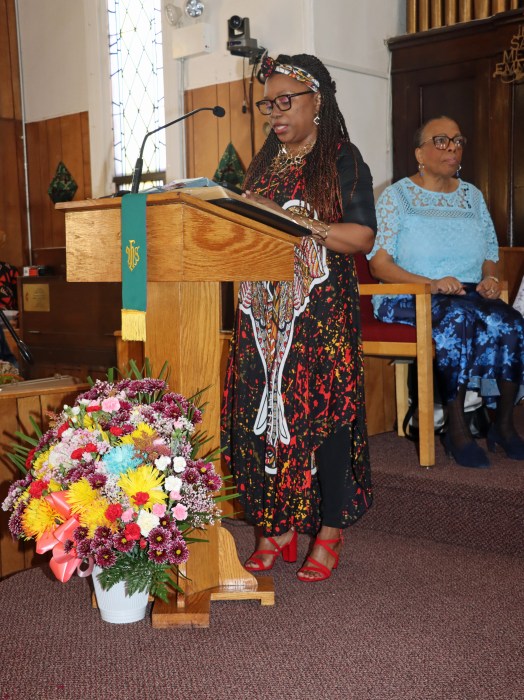 Grenadian Natalie Wilson narrates "African American and Labor" struggles with Vincentian Liturgist Min. Cynthia Grant is seated in the background.