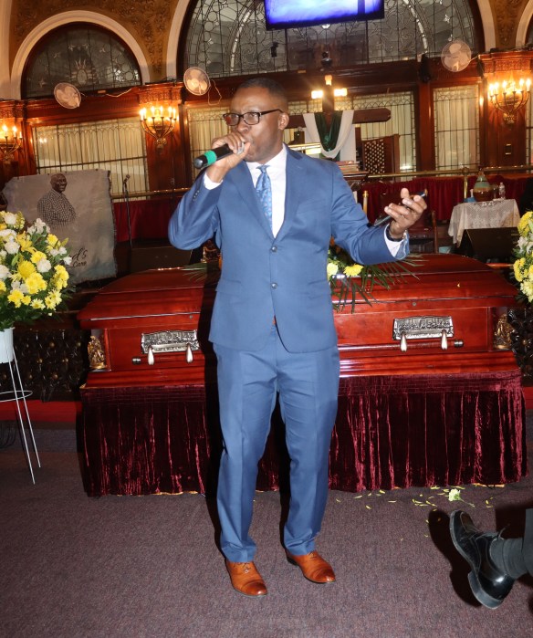 Trinidadian Gerard Placide, McDonald Fest Gospel Winner, sings "How Great Thou Art”in front of the casket.
