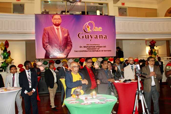 The audience listens in rapt attention as CG Ambassador Michael E. Brotherson and Ambassador Carolyn Rodrigues Berkett honor Guyana's 59th Anniversary of Independence, against the backdrop of an image of President Irfaan Ali, on May 21.
