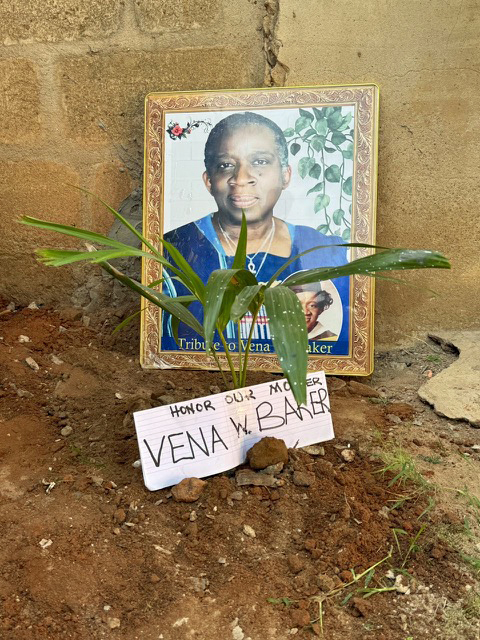 A photo of the late Vena W. Baker behind a palm tree planted in her honor in the village of Komeda Edna Aguafil in the central region of Ghana.