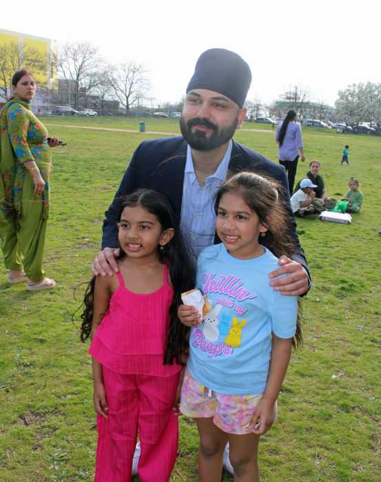Japneet Singh, candidate for New York City Council District 28, stooped to take a picture with two egg hunters at Police Officer Edward Byrne Park, in South Ozone Park, at an Easter Egg Hunt on April 19.