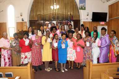 The Rev. Roger Jackson, back row, with mothers displaying their gifts.