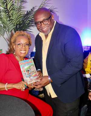 Author Sharon Gordon, left with Lyndon Taylor, Founder & CEO at Lynton Taylor Associates, holding a signed copy of novel Sherribaby, at an April 24 launch at Seas Lounge in Brooklyn.