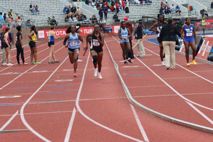 Bespectacled J'niah Goodard (BF) anchors (fourth leg) in 4x400m for Thomas Saunders Secondary School.