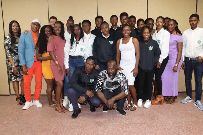 James Cordice (stooping, right) with support staff and athletes of the Emmanuel High School Mesopotamia, St. Vincent and the Grenadines at the reception for athletes participating in the 2025 Penn Relays.