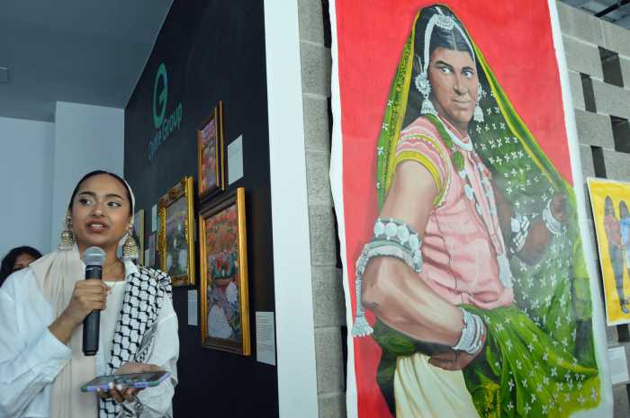 Curator Rekiba Zaman speaks with attendees at the “Current Currents” exhibition, which celebrates Indo-Caribbean heritage through visual art, spoken word, literature, and film.