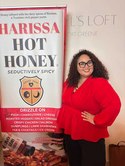 Gloribelle Perez poses with her product at a food and beverage event in New York. She continues to expand Harissa Hot Honey into a nationally recognized and trusted brand.