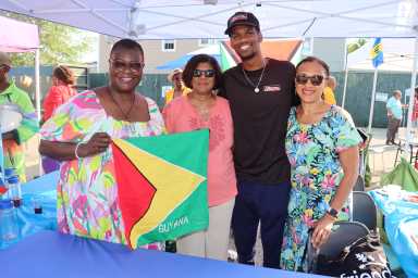Sen. Roxaane Persaud, left, displays Guyana flag, flanked by Betty Dyal, Anthony Rhone and Karen Wharton.