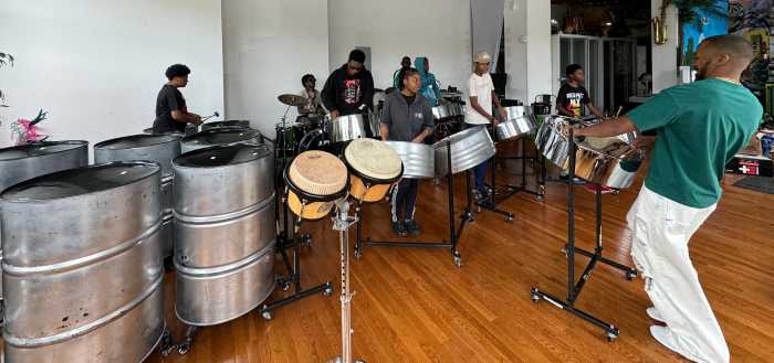 Joshua Regrello in front with tenor steelpan working with Tropicalfete’s SteelPan Ensemble giving back to the community.