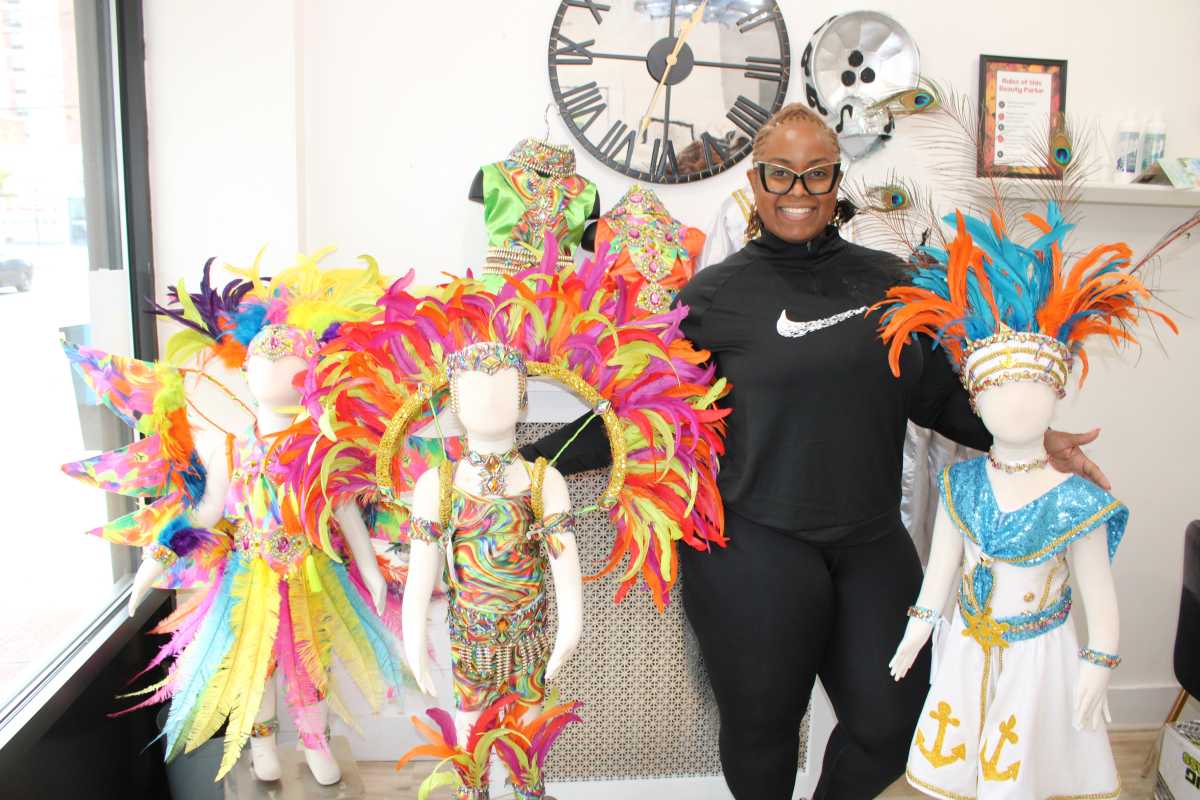 Costume designer and band leader Natasha Hinds of Karibbean Island Pulse Kidz, surrounded by costumes ready for children to compete in the August 30 Junior costume competition on the streets of Crown Heights, and the Brooklyn Museum grounds.