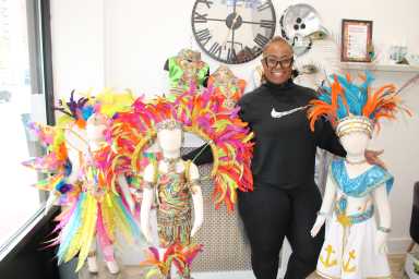 Costume designer and band leader Natasha Hinds of Karibbean Island Pulse Kidz, surrounded by costumes ready for children to compete in the August 30 Junior costume competition on the streets of Crown Heights, and the Brooklyn Museum grounds.