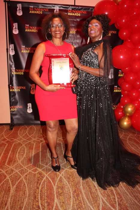 Kettly Mars, left, receives award in October 2024 from Dr. Cynthia Sterling-Fox, marketing and promotions for the SUNSHINE AWARDS.
