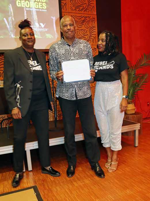 Sir Hilary Beckles shows his citation from NYC Mayor Eric Adams, flanked by Marsha Massiah, right, and Melany Paynter.