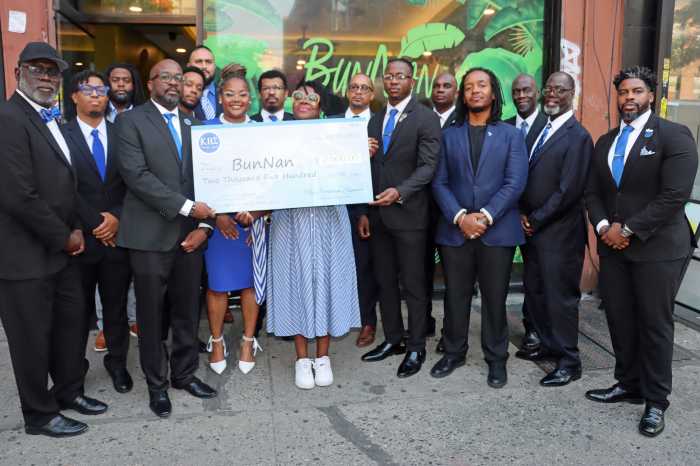 Nadege Fleurimond, center, displays check from Brooklyn Sigmas, flanked by Dr. Luc Severe's sister, Rebekah Severe, to Fleurimend's immediate right, and members of the Brooklyn Sigmas.