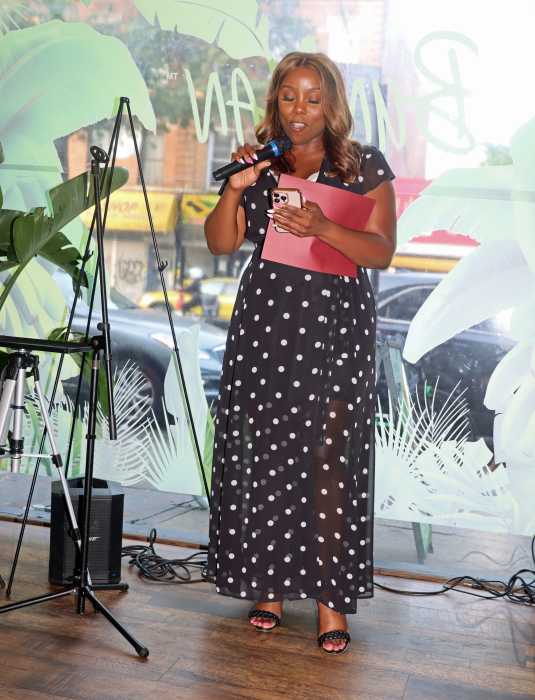 Holding the citation, Council Member Farah N. Louis addresses the ceremony.