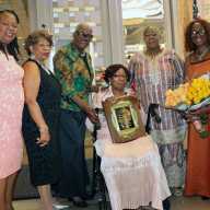 Retired, Guyanese-born, Registered Nurse Margaret Clara Burke receives CANA Lifetime Achievement Award, flanked by, left to right, CANA President-Elect Dr. Olga Husbands; Mistress of Ceremonies Dr. Jean Leon; Retired Registered Nurse Celia Bramble; incumbent CANA President Registered Nurse Barbara Osborne; and Burke's niece, Heather Mitchell, with bouquet of flowers.