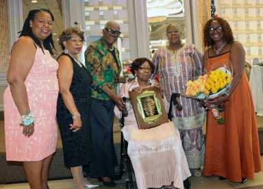 Retired, Guyanese-born, Registered Nurse Margaret Clara Burke receives CANA Lifetime Achievement Award, flanked by, left to right, CANA President-Elect Dr. Olga Husbands; Mistress of Ceremonies Dr. Jean Leon; Retired Registered Nurse Celia Bramble; incumbent CANA President Registered Nurse Barbara Osborne; and Burke's niece, Heather Mitchell, with bouquet of flowers.