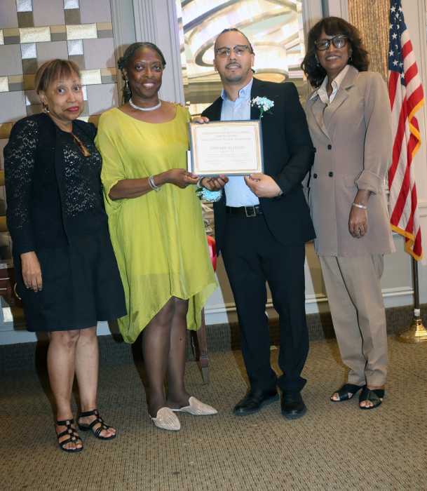 Dr. Marlene Lofters-Dinham, second from left, presents the Lena Osborne Wynter Scholarship Award to Dominican Republic-born Edward Alonzo, who is currently pursuing a nursing degree at Brooklyn’s Medgar Evers College, City University of New York, flanked by Wynter's daughters, Lori-Ann Wynter, left, and Diana Wynter, right.