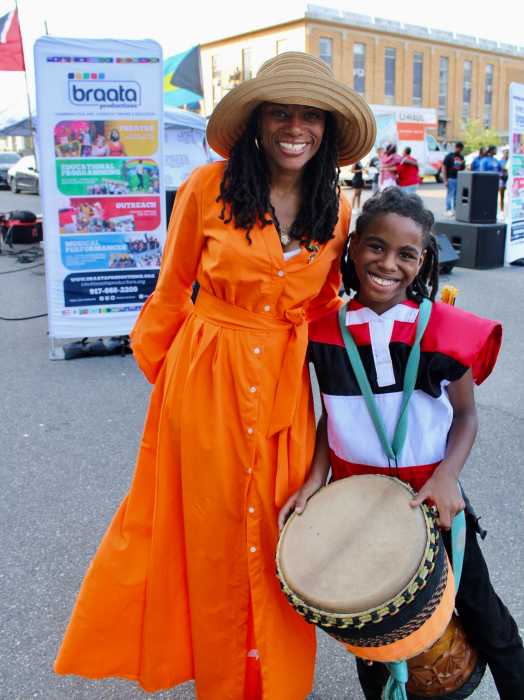 Eleven-year old, Jayden all smiles with Assembly Member Monique Chandler-Waterman, after a spirited drumming performance that got celebrants on their feet at the Aug. 10, a colorful Bankra Caribbean Folk Festival on the Holy Family Church tarmac in Canarsie, Brooklyn.